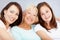 Beautiful portrait of the family girls. Three generations of girls sitting together on the lounge sofa together smiling.