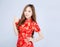 Beautiful portrait happy Chinese New Year young asian woman wear cheongsam fashion smile and cheerful with gesture thumbs up