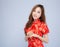 Beautiful portrait happy Chinese New Year young asian woman wear cheongsam fashion smile with gesture congratulation