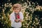 Beautiful portrait of little ukrainian boy in dandelions garden. Child in traditional embroidery vyshyvanka shirt