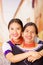 Beautiful portrait of mother with daughter, both wearing traditional andean clothes and matching necklaces, posing