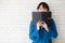 Beautiful portrait young asian woman happy hiding behind covering the book with cement or brick concrete background