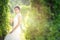 Beautiful portraits with natural light asian woman bride in wedding dress in nature meadow flower,standing in green grassy field