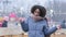 Beautiful positive afro american girl ethnic millennial girl stands outdoors against background of city ice rink people