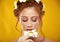 Beautiful positive redheaded girl with a chamomile crown on her head