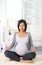 Beautiful Pregnant asian Woman Doing Yoga at Home. Relaxation