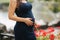 Beautiful pregnant lady in blue dress smile. Tenderness woman walk outside. Six months of pregnancy