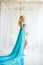 Beautiful pregnant woman. Attractive blonde touching naked belly posing in blowing drapery dress flying on wind