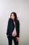 a beautiful pregnant woman in a black jacket with bare breasts and a belly