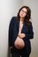 beautiful pregnant woman in glasses and black jacket with bare breasts and belly
