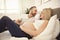 Beautiful pregnant woman and her handsome husband spending time together in bed