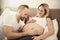 Beautiful pregnant woman and her handsome husband spending time together in bed