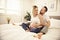 Beautiful pregnant woman and her handsome husband spending time together in bed