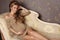 Beautiful pregnant woman with long blond hair wears elegant dress