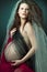 Beautiful pregnant woman with long curly hair.