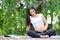 Beautiful pregnant woman look her belly with the concern of her baby and sit in garden or park