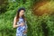Beautiful pregnant woman mother to be in wreath and blue dress standing in sunset light in summer. Pregnancy and healthy organic