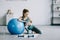 beautiful pregnant woman palming puppy and leaning on fitness ball