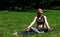 Beautiful pregnant woman practicing yoga in summer park. Beautiful pregnant woman sitting on grass