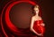 Beautiful pregnant woman in red silk dress billowing