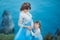 Beautiful Pregnant Woman in romantic flying dress at sea with daughter near ancient ruins of Greece city Gorgeous pregnant girl in
