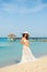 Beautiful pregnant woman on a sandy beach makes a heart on the background of the tummy. Caribbean Sea.