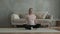 Beautiful pregnant woman is sitting on floor in lotus position