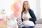 Beautiful pregnant woman with sonogram image at baby shower party