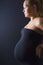 Beautiful pregnant woman stand with hands on the back