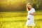 Beautiful pregnant woman in summer nature meadow with yellow flo