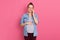 Beautiful pregnant woman talking on phone against pink wall, wearing casual clothing, looking at camera, holds smart phone,