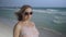 Beautiful pregnant woman walking on the ocean beach, Young woman waiting for her baby, stroking his stomach 4k