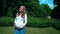 Beautiful pregnant woman walking in park on summer sunlight