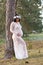 Beautiful pregnant woman in white sheer maternity dress outdoors
