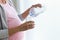 Beautiful pregnant young woman putting water in a glass at home