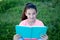 Beautiful preteen girl with blue eyes reading a book