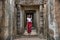 Beautiful, pretty, young Thai girl is exploring the ancient ruins of Angkor Wat City/Capital of Temples Hindu temple complex in