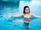 beautiful professional asian woman practice aqua yoga water therapy side bend twist pose balance in swimming pool body mind spirit