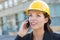 Beautiful Professional Young Woman Contractor Wearing Hard Hat on Site Using Phone