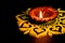 Beautiful profile shot of earthen oil lamp glow on rangoli and black background. diwali concept