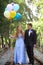 Beautiful Prom Couple Walking with Balloons Outside