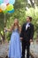 Beautiful Prom Couple Walking with Balloons Outside