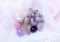 Beautiful purple amethyst stones and amethyst quartz crystals on a white transparent fabric. Cactus quartz, known as spirit quartz