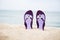 Beautiful, purple flip-flops on the beach