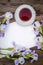 Beautiful purple flowers irises, a sheet of paper and a cup of tea on a wooden background