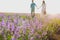 Beautiful purple lavender flowers on the summer field. Blurred Couple hugging hands, romantic love story. Warm and inspiration