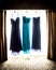 Beautiful purple and teal bridesmaid dresses hanging in a window
