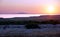 Beautiful purplish sea sunset above rural landscape with dry stone wall