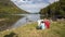 Beautiful Pyrenees mountain landscape, nice lake with tourist couple looking a map. Spain, Catalonia