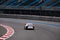 A beautiful racing car drives along the race track and moves away from the camera